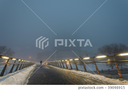 Silhouette of a man in a thick fog at night Silhouette of a man in a thick fog at night 39098915