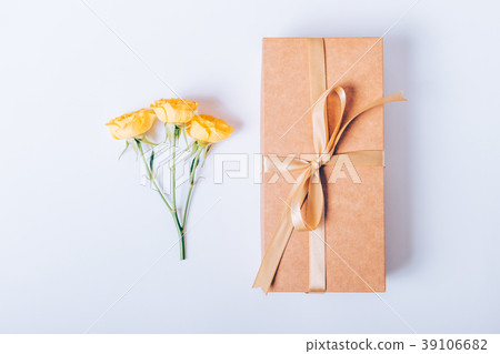 Gift box with beige ribbon and small yellow roses 39106682