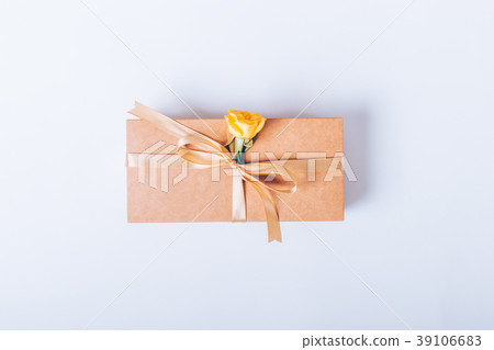 Gift box with beige ribbon and yellow flower 39106683
