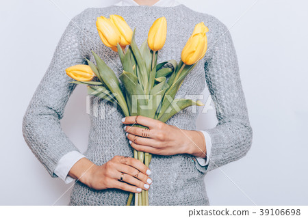 Girl in a gray sweater is holding a bouquet Girl in a gray sweater is holding a bouquet 39106698