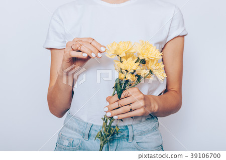 Girl in a T-shirt and jeans is holding a bouquet Girl in a T-shirt and jeans is holding a bouquet 39106700