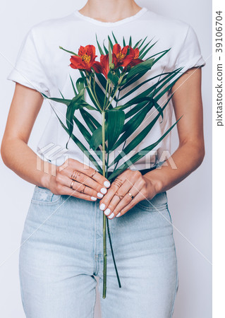 Slender woman holding a bouquet of red flowers Slender woman holding a bouquet of red flowers 39106704