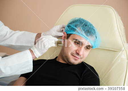 Man during otolaryngologist checkup Man during otolaryngologist checkup 39107358