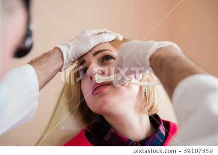 Ent doctor check nose of female patient 39107359