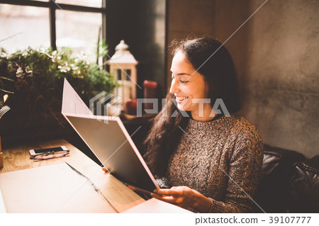 business girl studying the menu in restaurant 39107777