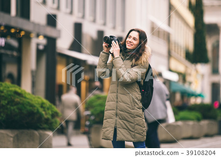 Beautiful young tourist woman stands on the Beautiful young tourist woman stands on the 39108204