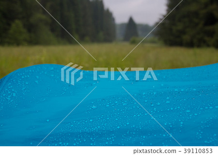 Water drops closeup on a blue tent in a forest Water drops closeup on a blue tent in a forest 39110853