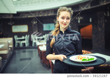 Waiters carrying plates with food, in restaurant. Waiters carrying plates with food, in restaurant. 39121167