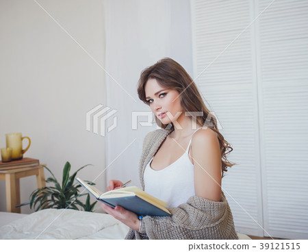 Smiling woman writing in book 39121515