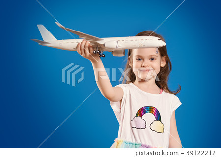 girl is holding a white plane and smiling girl is holding a white plane and smiling 39122212