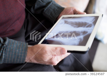 old man observing a chest radiograph in a tablet old man observing a chest radiograph in a tablet 39124587