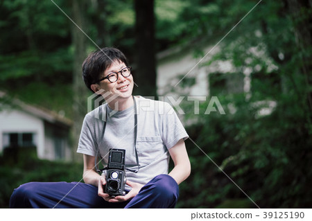 男子手持雙鏡頭反光相機在露營地 男子手持雙鏡頭反光相機在露營地 39125190