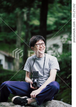 男子手持雙鏡頭反光相機在露營地 男子手持雙鏡頭反光相機在露營地 39125192