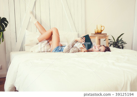 Pretty woman enjoying reading a book at home Pretty woman enjoying reading a book at home 39125194