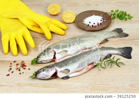 Fresh raw trout fish with spices and rubber gloves 39125250