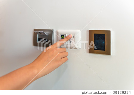 Woman hand being turn on temperature switches  39129234