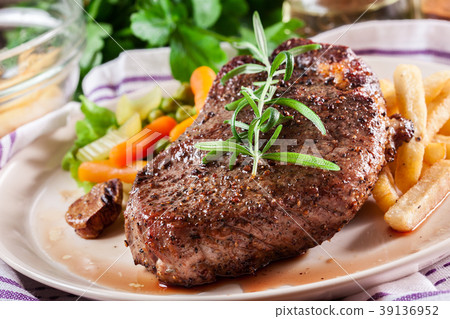 Beef steak served with baked potatoes 39136952