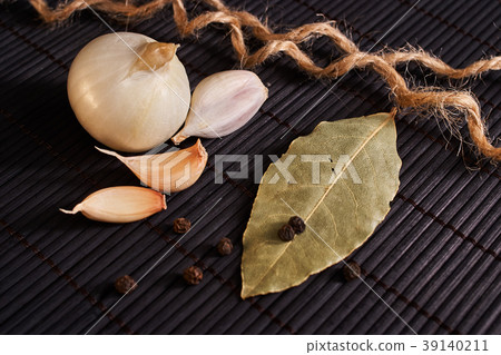 onion, garlic, black pepper and bay leaf on black onion, garlic, black pepper and bay leaf on black 39140211