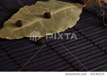 bay leaf and black pepper on a black background bay leaf and black pepper on a black background 39140214