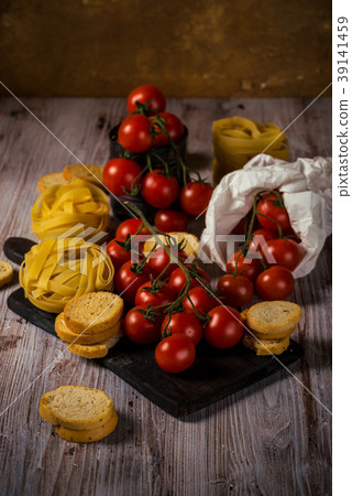 Red cherry tomatoes on several twigs with pasta 39141459