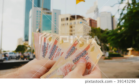 Man recounts Vietnamese money. Two hundred and one 39143296