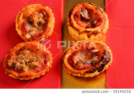 Mini pizza topped with cherry tomatoes and capers Mini pizza topped with cherry tomatoes and capers 39144258