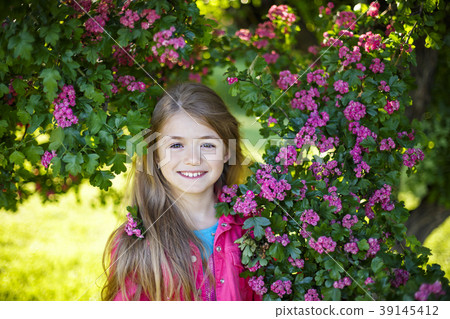 Pretty smiling girl in pink blossom garden 39145412