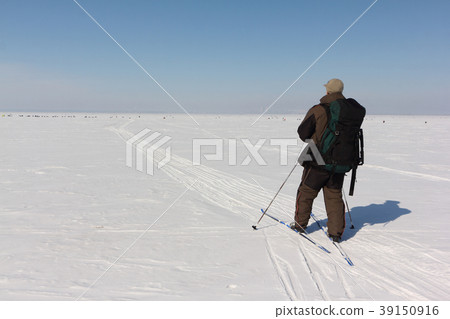 Man with a backpack is skiing on a snowy river Man with a backpack is skiing on a snowy river 39150916