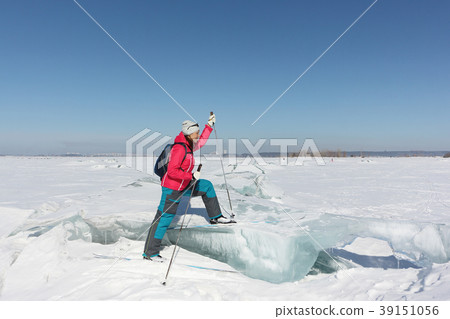 Happy woman skier stepping on an ice floe Happy woman skier stepping on an ice floe 39151056