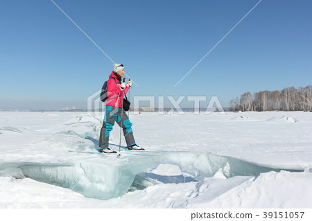 Happy woman skier standing on an ice floe Happy woman skier standing on an ice floe 39151057