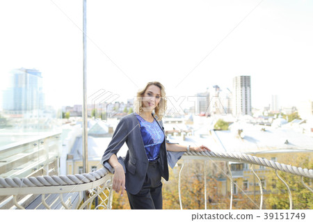 Businesswoman standing on balcony with skyscrapers 39151749