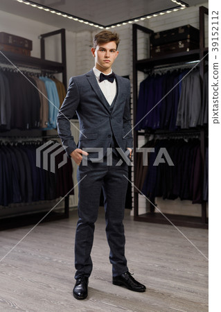 Businessman in classic vest against row of suits Businessman in classic vest against row of suits 39152112