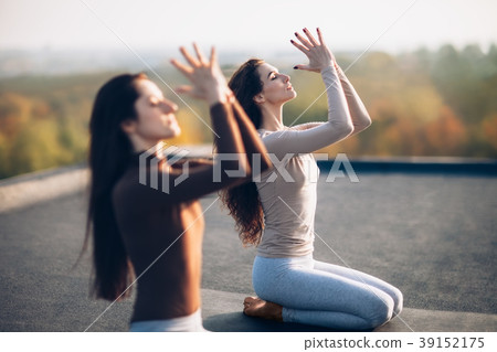 Two young beautiful women doing yoga asana on the roof outdoor Two young beautiful women doing yoga asana on the roof outdoor 39152175