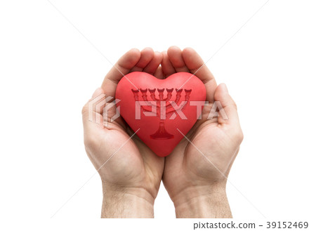 Red heart with imprinted menorah in man's hands.  39152469