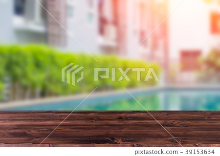 Wooden table with blur condominium pool Wooden table with blur condominium pool 39153634