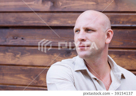 portrait of handsome bald man, on the wooden brawn 39154137
