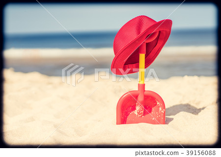 Red shovel and straw hat on the beach 39156088