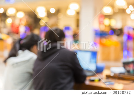 Blurred picture of two people using their computer 39158782