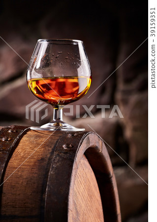 Glass of cognac on the old wooden barrel 39159351