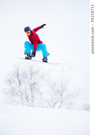 Photo of sportive male snowboarder jumping on 39159731