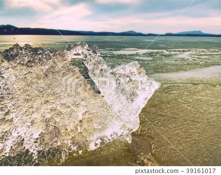 Heap of shining ice on beach. Ice in overlaid bay Heap of shining ice on beach. Ice in overlaid bay 39161017