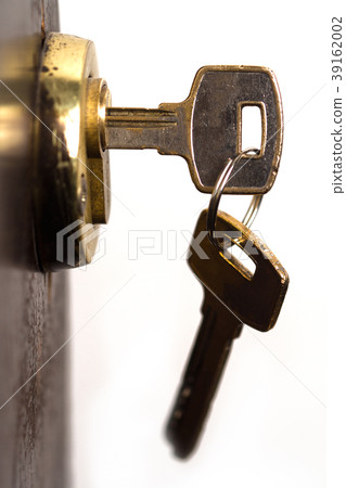 closeup of pair of keys in wooden door lock closeup of pair of keys in wooden door lock 39162002