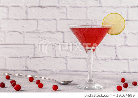 Glass of cosmopolitan cocktail decorated with lime 39164699