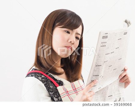 Troubled woman looking at economic newspaper 39169068
