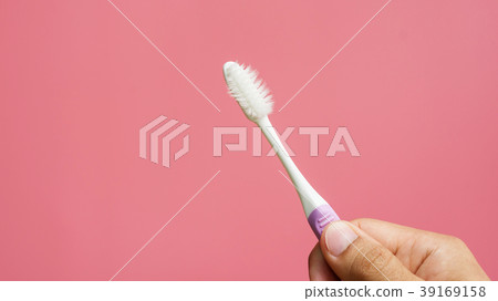 Men holding old toothbrush on a pink background. Men holding old toothbrush on a pink background. 39169158