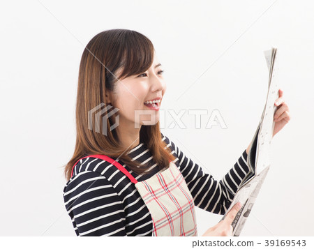 Smiling woman looking at economic newspaper Smiling woman looking at economic newspaper 39169543