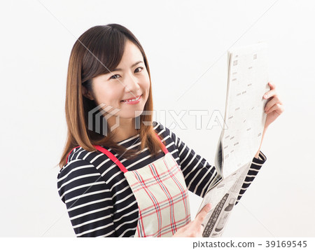 Smiling woman looking at economic newspaper Smiling woman looking at economic newspaper 39169545