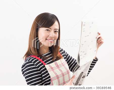 Smiling woman looking at economic newspaper Smiling woman looking at economic newspaper 39169546