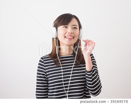 A woman listening to music with headphones A woman listening to music with headphones 39169578