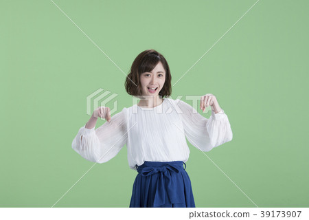 Young woman pointing down green back Young woman pointing down green back 39173907